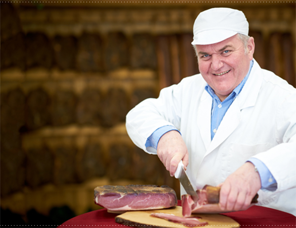 Franz Petregger (Tiroler Metzgermeister) beim aufschneiden eines Landler-Schinkens